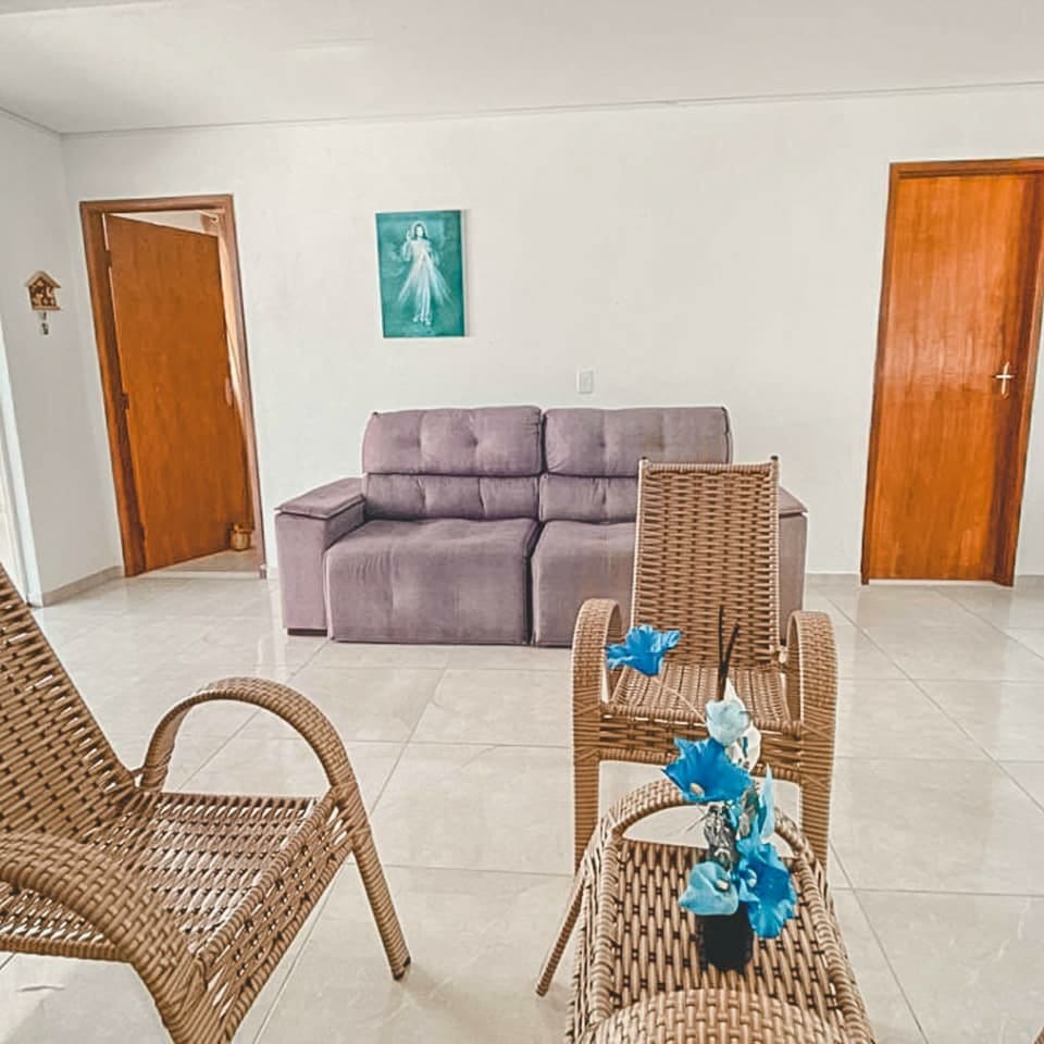 Sala de estar com sofá e poltronas de vime